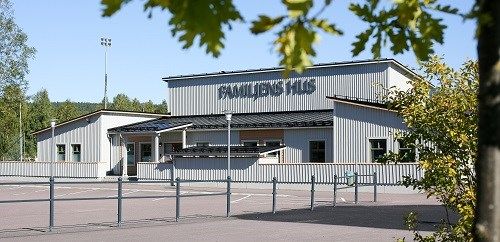 Grå träbyggnad med skylt som säger: Familjens hus