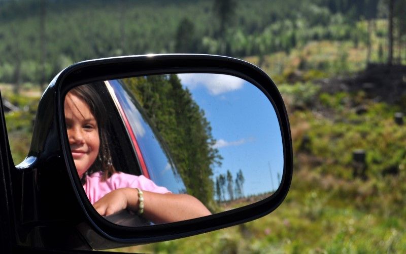 Flicka tittar i en backspegel