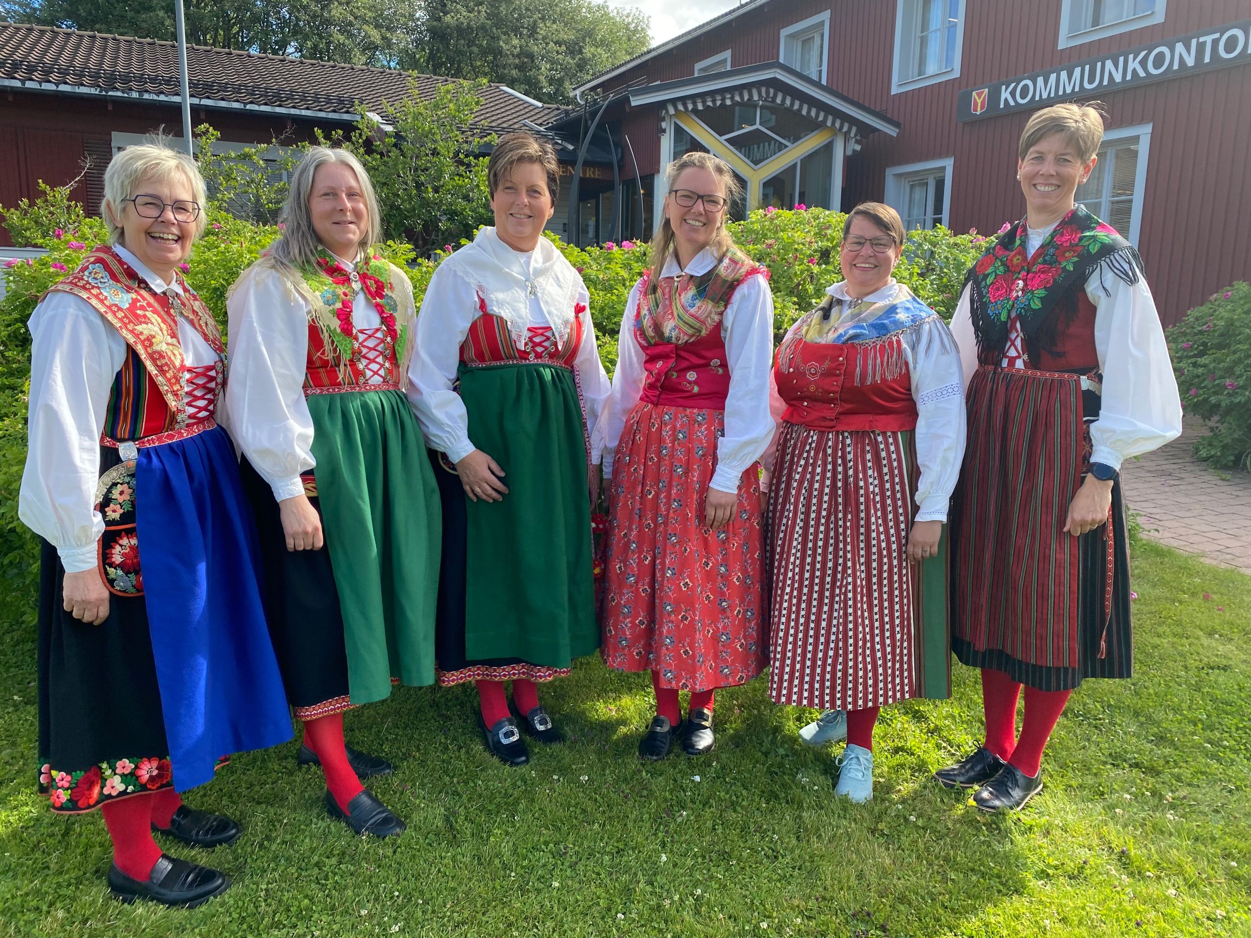 Sex personer utomhus iförda folkdräkter.